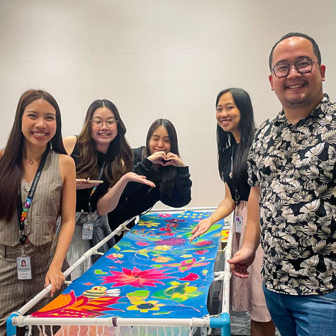 Agoda employees drawing batik wax designs at individual stations during corporate workshop at CentralWorld Bangkok