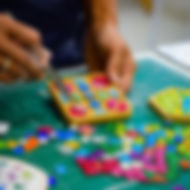 Students arranging mosaic tiles during a Mosaic Art Workshop at GIGIPAYNE Studio in Bangkok.