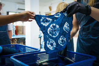 Participants folding and tying fabric during a Shibori Indigo Tie Dye workshop at GIGIPAYNE Studio in Bangkok