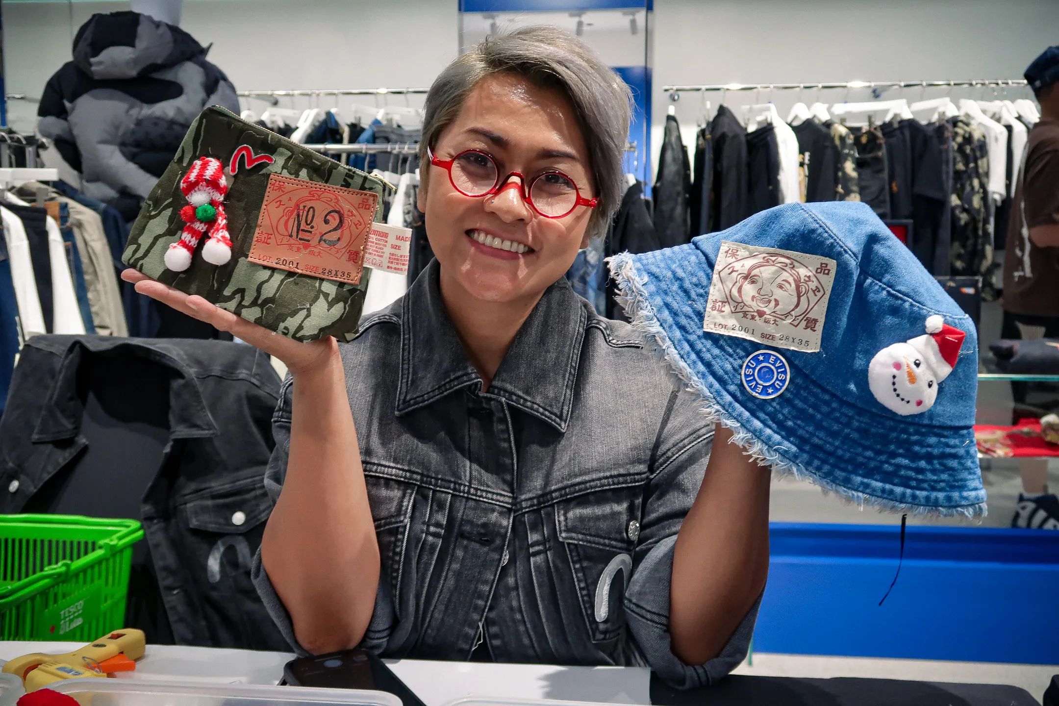 visitors customising evisu denim crossbody bags with patchwork and embroidery at evisu bangkok flagship anniversary event by GIGIPAYNE