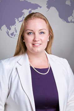 Female executive in white jacket on gray backdrop with world map at LPS Headshot Studio