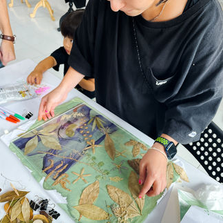 Asian woman making cyanotypes with botanical print.