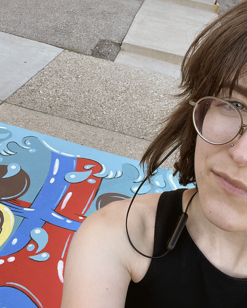 A selfie of the artist Emily Hromi in front of her finished sidewalk mural.