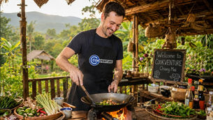 A digital nomad learning traditional woodfire cooking in Chiang Mai to apply for the DTV Soft Power Visa.