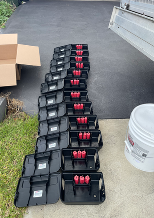 Multiple black pest control bait stations with red inserts
