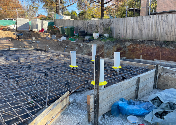 Construction site with rebar and pipes in foundation