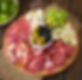 antipasto-catering-platter-with-bacon-jerky-salami-cheese-grapes-wooden-table.jpg
