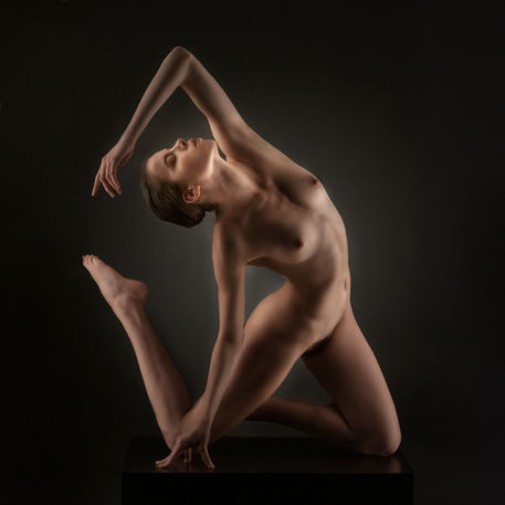 Künstlerische Aktfotografie einer Frau in einer dynamischen Körperpose