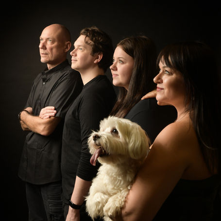 Vierköpfige Familie mit weißem Hund bei einem stimmungsvollen Familienfotoshooting in Wiener Neustadt