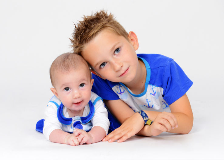 Baby und älterer Junge in abgestimmter blauer Kleidung bei einem Geschwister-Fotoshooting in Wiener Neustadt