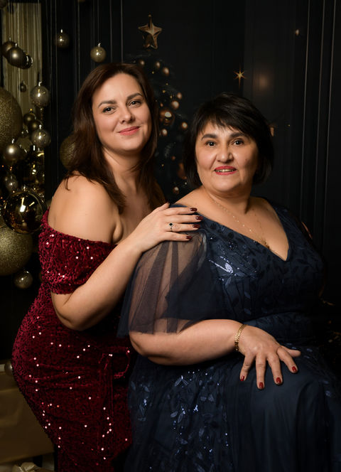 Zwei Frauen in eleganten roten und dunkelblauen Kleidern bei einem Weihnachtsfotoshooting in Wiener Neustadt
