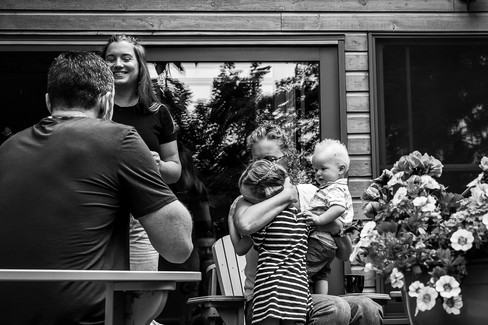 Mother comforts her crying daughter while also holding infant son during a documentary family photoshoot in Kincardine