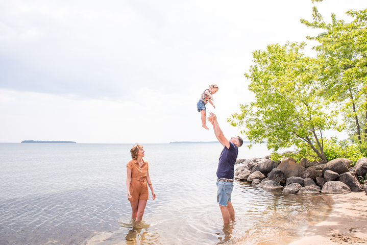 Dad throws daughter in the air at Port Elgin Beach during family photo session
