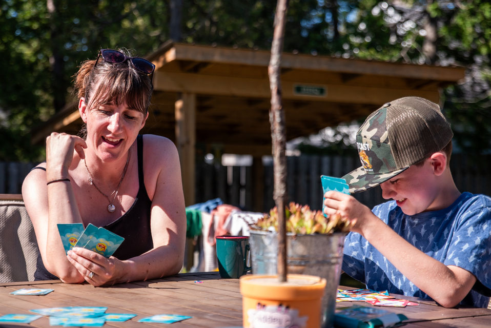 Mom plays go fish with son during documentary photo session in Sauble Beach Ontario