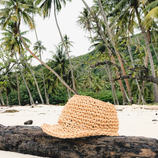 Crochet summer hat on palm tree