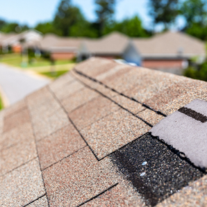 Damaged loose asphalt shingle on a residential roof