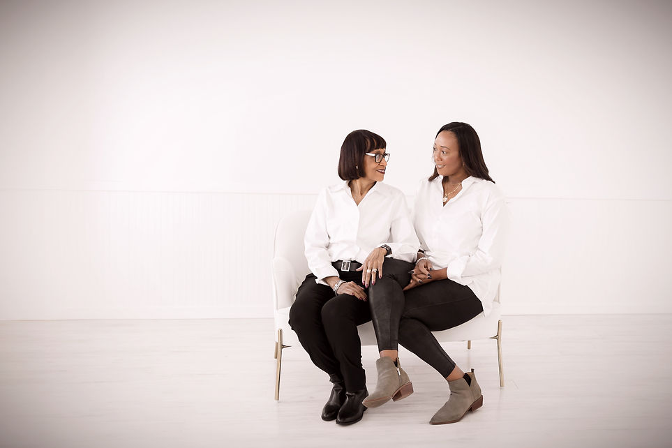 A mother and daughter wearing Angel Whisper memorial pendant necklaces. They are smiling and looking at each other with love.