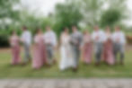 Wedding party walking on grass, bridesmaids in mauve dresses, groomsmen in grey suits, joyful mood, lush greenery backdrop at a wedding venue near new bern. Wedding Venue in Eastern NC
