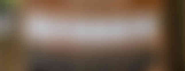 A wooden sign that has Find your seat printed on the top and is holding table number cards on a twine with clothespins and cards for each table number with a list of wedding guest names for each table at a wedding venue in Carteret county nc.