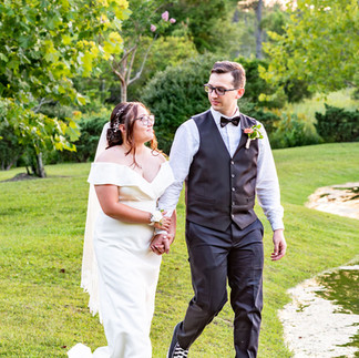 Bride and groom walking hand-in-hand beside the lake at Butterfly Kisses Pavilion in Newport, NC.