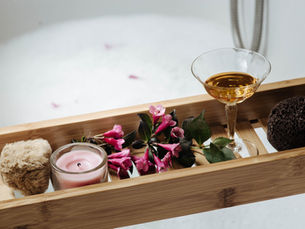 Wine glass, candle, loofahs, flowers and natural bath products 