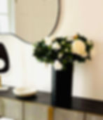 Beautifully organised hallway console styled with modern décor and an organic mirror.