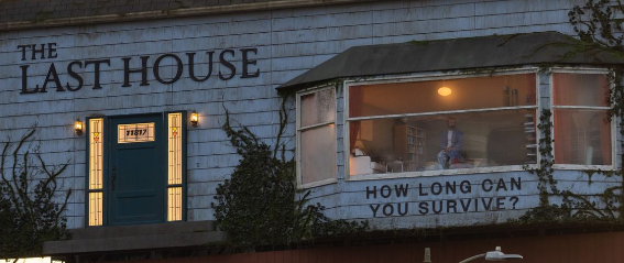 Full view of The Last House billboard on Sunset Boulevard at sunset, styled as a weathered house with ivy, a lit window, and a blue front door, with Netflix signage below