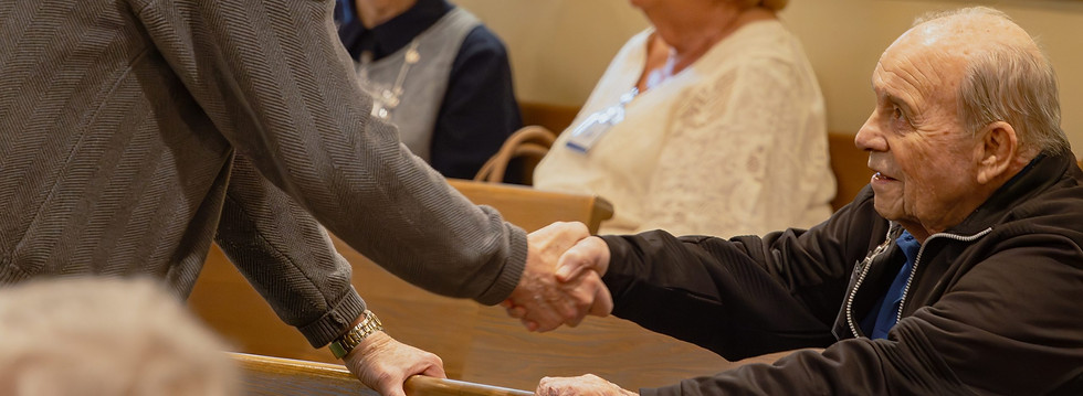 Two men shake hands before Sunday morning service.