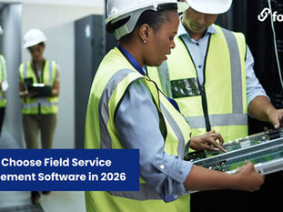 man and woman wearing high-vis jackets looking at computer server