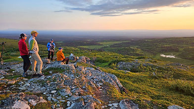 Guests at Caribou Lodge enjoy a sunset view during an evening hike.