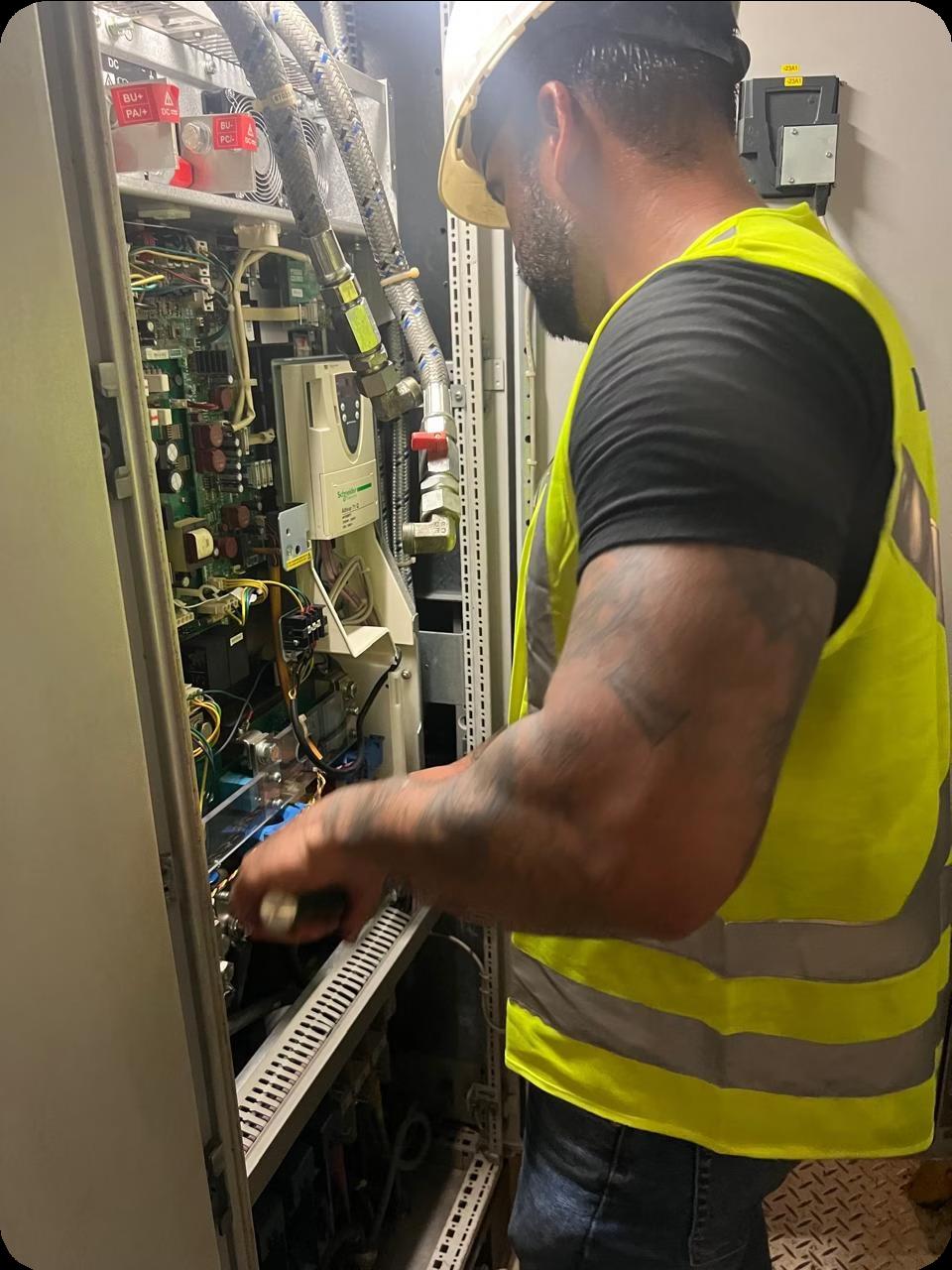 ForgeTech technician diagnosing an electrical control panel