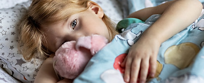 a-little-girl-lies-under-a-blanket-with-a-toy-dog-2025-03-10-12-42-15-utc.jpg