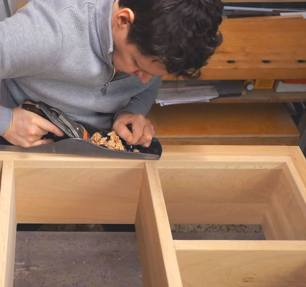 Miniatura: Záber na sústredeného stolára s hoblíkom v ruke pri výrobe Dubovej Knižnice