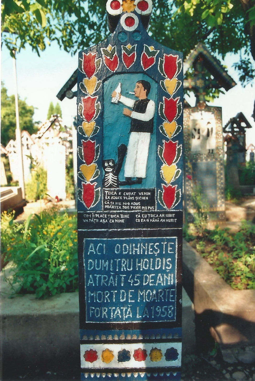 A cross with the picture and a short funny story about how the deceased died.