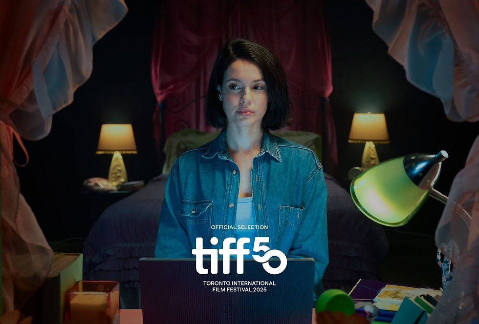 Woman in denim jacket sits at a desk with a laptop in a dimly lit bedroom. Two lamps create a cozy atmosphere. Text: "TIFF 50, 2025."