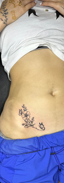 Floral tattoo on stomach and arm, Inkaholicz, original piece, blue pants, white top