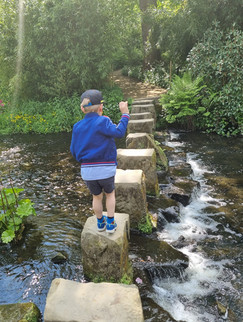 Boy crossing tall stepping stones
