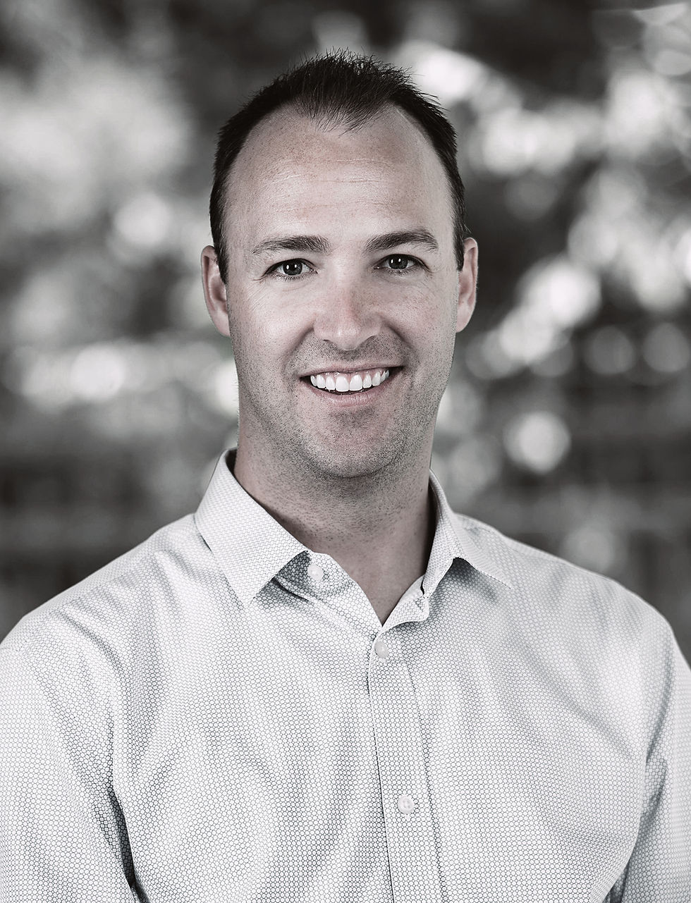 a man in a white shirt smiles at the camera.