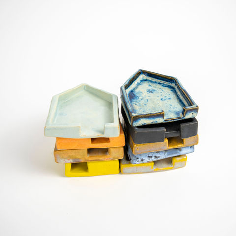 Colorful stack of ceramic house-shaped trays on white background Sun Parlor Studio