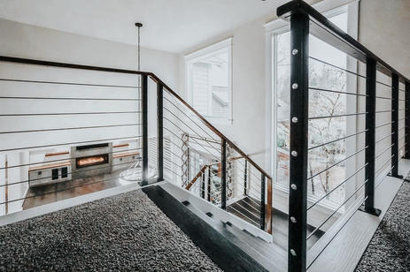 a cable railing looking over a newly remodeled living room