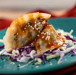 Steamed dumpling topped with sesame seeds and savory sauce at EPCOT International Flower & Garden Festival Outdoor Kitchen.