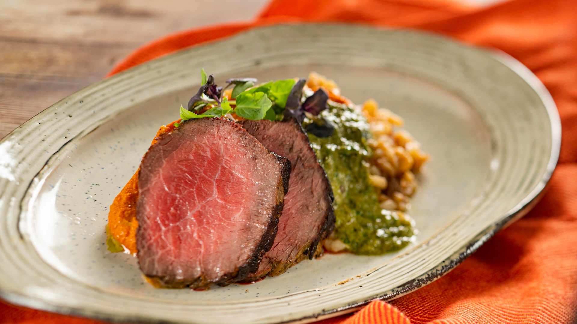 Grilled beef strip loin with risotto and herb sauce from EPCOT International Flower & Garden Festival Outdoor Kitchen at Walt Disney World, featuring popular festival savory dishes and curated Disney dining recommendations from travel advisor Brandi Parker