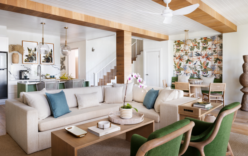 Bright, modern living room inside a luxury all-inclusive resort suite featuring a spacious open-concept layout, neutral coastal décor, plush sectional sofa, tropical accent wall, dining area, and kitchenette, highlighting a premium family-friendly resort accommodation ideal for Caribbean vacations, multigenerational travel, and January 2026 all-inclusive resort stays planned with an experienced travel advisor.