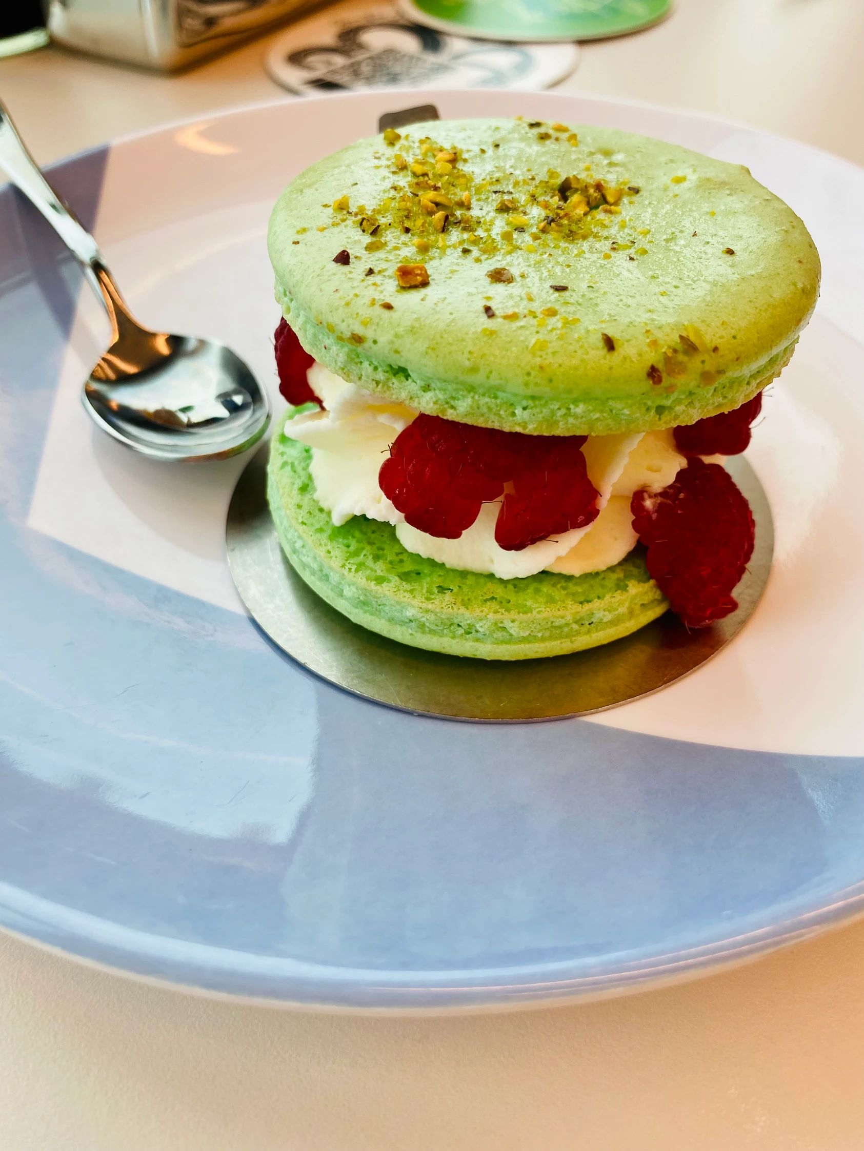 Bright green macaron dessert filled with cream and fresh fruit, showcasing the creative gourmet desserts available on upscale cruise ship menus.