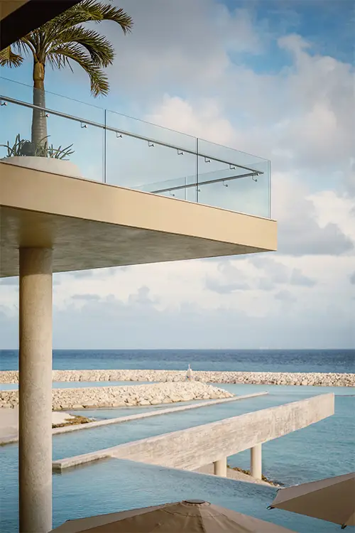 La Casa de la Playa oceanfront infinity pool terrace with modern minimalist architecture, glass railings, and panoramic Caribbean Sea views, highlighting exclusive adults-only luxury and beachfront all-inclusive escape in Riviera Maya.
