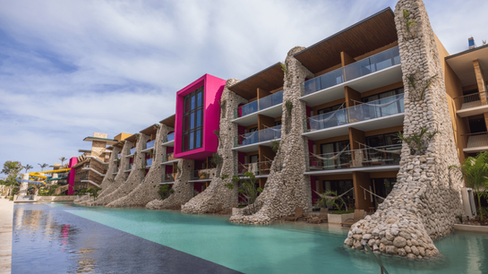 Hotel Xcaret Arte riverside suites in Riviera Maya showcasing eco-luxury architecture, swim-up waterways, and modern all-inclusive resort design for adults in Mexico.