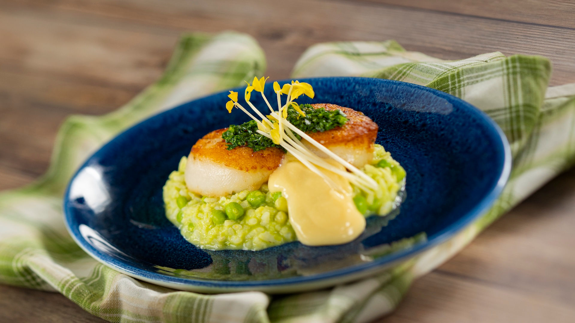 Seared scallop served over spring pea risotto at EPCOT International Flower & Garden Festival Outdoor Kitchen in Walt Disney World, highlighting premium festival menu items and expert Walt Disney World planning guidance from Disney travel advisor Brandi Parker.