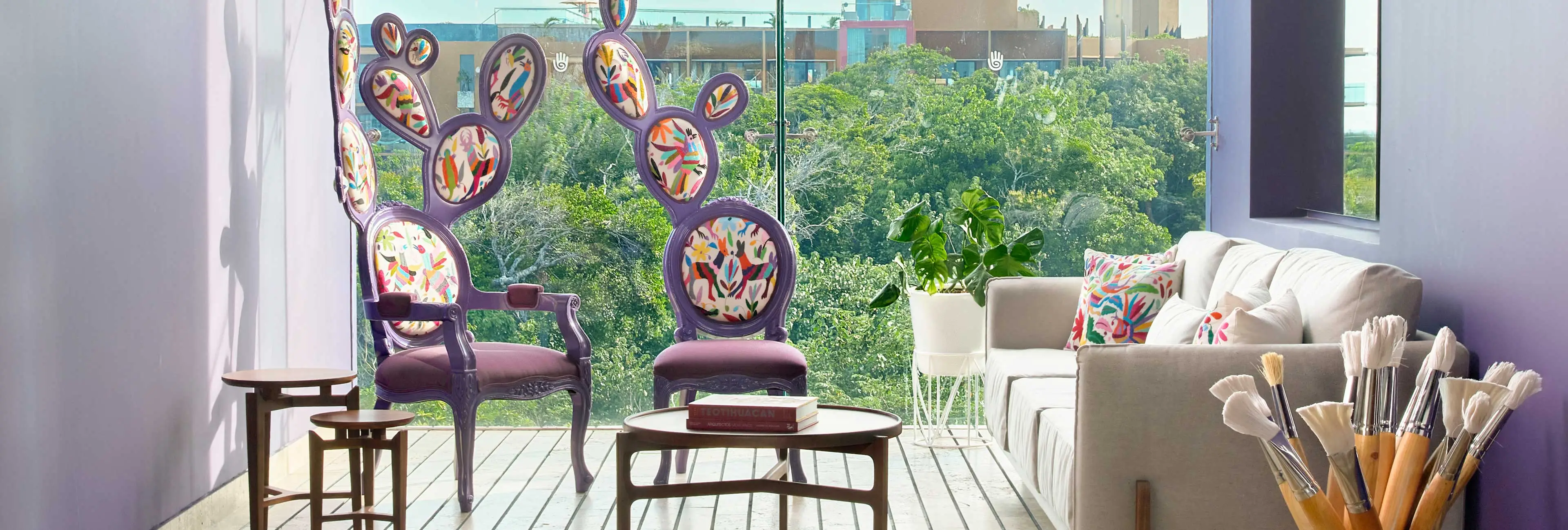Art studio lounge with hand-painted chairs, creative workspace, and jungle views at Hotel Xcaret Arte, featuring hands-on workshops, Mexican artistry, and immersive adults-only cultural experiences in Riviera Maya.