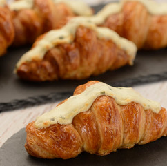 Fresh baked croissants topped with creamy glaze from EPCOT International Flower & Garden Festival Outdoor Kitchen, representing popular festival pastries and seasonal Disney snacks included in a Walt Disney World foodie strategy curated by travel planner Brandi Parker.