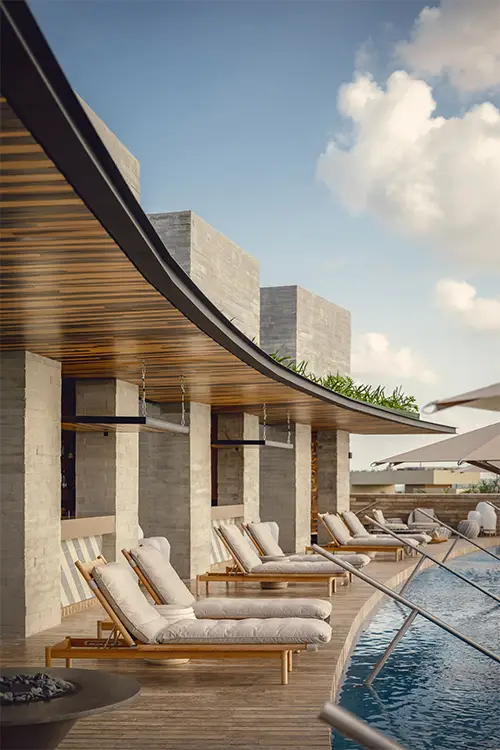 La Casa de la Playa rooftop-style pool deck with cushioned loungers, curved wood ceiling, and serene water views, showcasing ultra-luxury adults-only relaxation and private boutique resort ambiance in Riviera Maya.